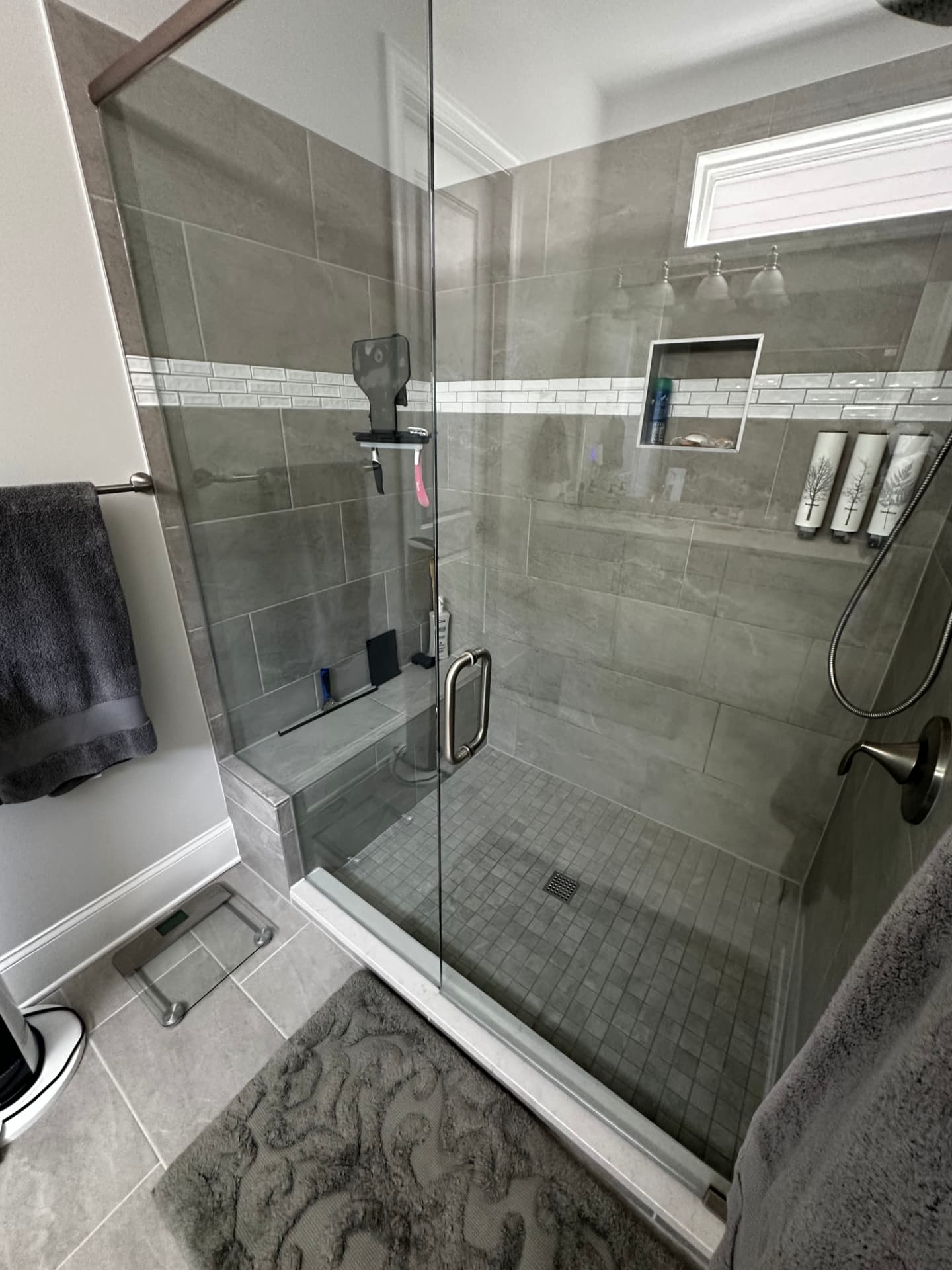 Tiled walk-in shower with streak-free glass after a detailed bathroom cleaning